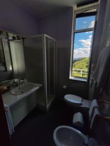 Madonna del SassoHotel Panoramico lago d'Orta的一间带两个盥洗盆和窗户的浴室