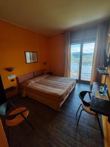 Madonna del SassoHotel Panoramico lago d'Orta的一间卧室设有一张床和一个大窗户