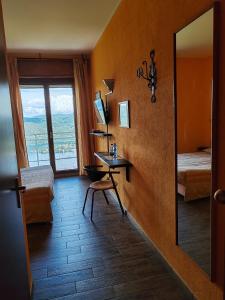 Madonna del SassoHotel Panoramico lago d'Orta的客房设有镜子、书桌和窗户。