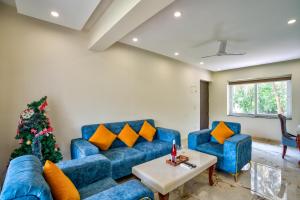 坎多林Premium 2BHK Apartment with pool at Candolim Beach的客厅配有蓝色的沙发和圣诞树