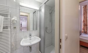 维也纳总站酒店的白色的浴室设有水槽和淋浴。