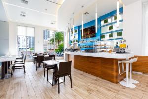 好莱坞Panoramic views Studio on the 27th floor Beachwalk的餐厅设有酒吧和桌椅