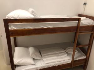 巴迪安Cuestas Beach Resort and Restaurant的双层床配有白色床单和枕头