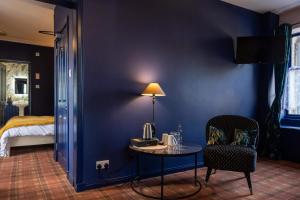 阿伯劳尔The Mash Tun的一间设有一张桌子和一张床的蓝色墙壁客房