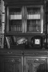 CerrazoHotel Palacio La Casona de Cerrazo的木柜,上面有书籍和钟表