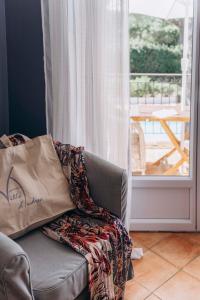 拉马蒂埃勒拉维拉德安德里亚酒店的一张沙发,上面装有袋子,窗户