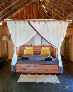 AmbatobeMiavaka Lodge的一间卧室配有一张带蚊帐的床