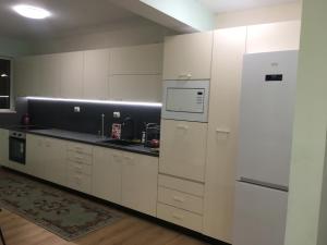 普罗夫迪夫Апартамент 170 кв.м за 6-ма, село Ягодово, Пловдивско的厨房配有白色橱柜和冰箱。