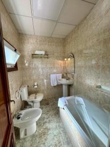 SabarisHotel Vasco Da Gama的带浴缸、盥洗盆和卫生间的浴室