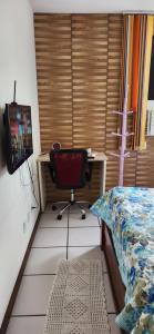 萨尔瓦多EDIFÍCIO METROPOLE ONDINA的一间卧室配有一张桌子和一张椅子,位于床边