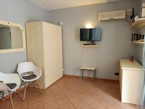 圣玛丽亚Sal&Love apt in Porto Antigo的一间带椅子、电视和白色橱柜的房间