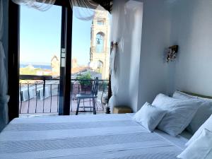 博兹贾阿达岛Vapori Otel的一间卧室设有一张床和一个美景阳台