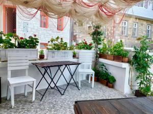 博兹贾阿达岛Vapori Otel的天井配有桌椅和盆栽植物