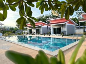 普吉镇พัชรี รีสอร์ท ภูเก็ต Patcharee Resort Phuket的别墅前的游泳池