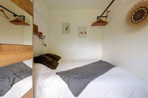 奈梅亨Tiny house - fietsverhuur, eigen keuken en badkamer的卧室两张照片,配有一张白色床