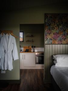 班特里Wild Hideaways Luxury Lodges and Eco Spa的卧室配有挂在墙上的白色长袍