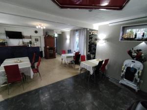 纳尔瓦约埃苏维阿格雷斯酒店的一间餐厅,房间内设有白色桌子和红色椅子