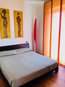 努马纳Appartamento sulla Riviera del Conero的卧室配有一张床,墙上挂有两幅画