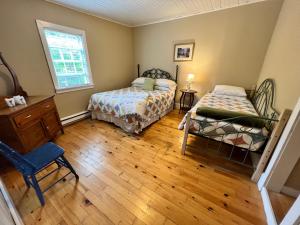 特里尼蒂毕晓普白色庄园宾馆的一间卧室设有两张床和窗户。