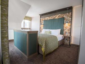 锡米尔The Waterside Hotel的一间卧室配有一张带木制床头板的床
