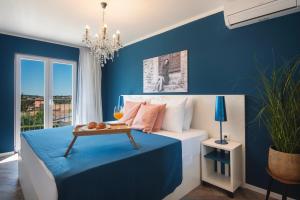 普拉Vinkuran Residence - Adults Only的一间卧室设有蓝色的墙壁和一张带桌子的床