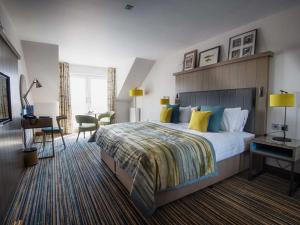 锡米尔The Waterside Hotel的酒店客房设有一张大床和一张书桌。