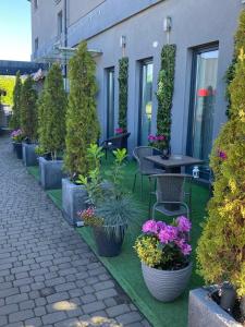 克拉科夫Aparthotel Lumen的庭院里种植了盆栽植物,配有桌椅