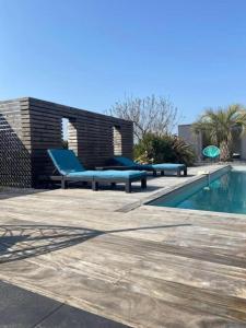 La Guerche-de-BretagneJolie maison avec piscine et Spa的游泳池旁的蓝色长凳