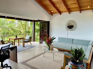 乌维塔Oxygen Jungle Villas & Spa的客厅配有沙发和桌子