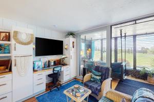 瓦克拉Golfer’s Lava Cove的客厅配有电视、书桌和椅子