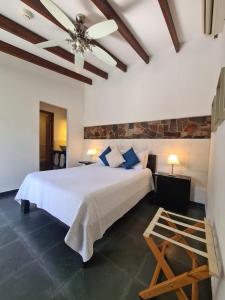 科洛尼亚-德尔萨克拉门托蚕茧酒店的卧室配有白色的床和吊扇