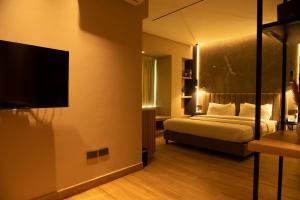 拉各斯Vertigo Hotel的一间卧室配有一张床和一台平面电视
