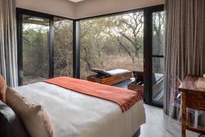 斯库库扎Rixile Kruger Lodge的一间卧室设有一张床和一个大窗户