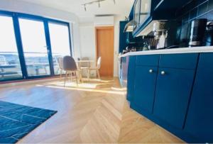 卢森堡One bedroom flat with Terrace and private Parking -51B的厨房配有蓝色橱柜和桌椅