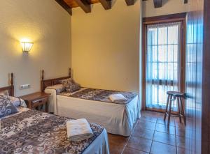 坎姆帕拉斯Can Tubau - Casa rural - Apartaments的客房设有两张床和窗户。