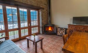 坎姆帕拉斯Can Tubau - Casa rural - Apartaments的客厅配有木桌和壁炉