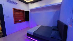 乌贾因PALLAV GUEST HOUSE的一间卧室配有一张紫色灯床