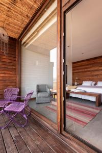 皮奇勒姆Hotel Alaia的一间卧室设有1张床和1扇玻璃门的阳台