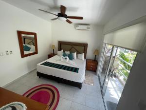 坎昆Home's Jungle Puerto Morelos Cancun 20 Minutes from the Airport的一间卧室配有一张床和吊扇