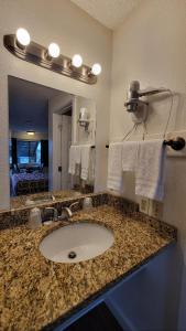 西雅图奈特斯汽车旅馆的浴室配有盥洗盆、镜子和毛巾