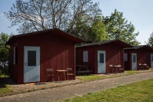布拉格Prague Camping Dzban的道路上两座红色小屋 - 带桌椅
