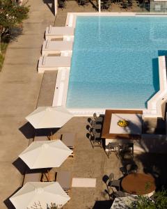 普拉基亚斯普拉基亚斯阿波罗酒店的享有带桌子和遮阳伞的游泳池的顶部景致