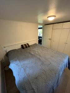 厄勒布鲁Gläntan Cosy Newly Renovated Summerhouse的一间卧室配有一张带蓝色棉被的床