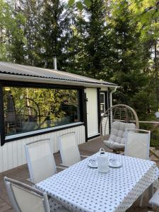 厄勒布鲁Gläntan Cosy Newly Renovated Summerhouse的庭院里的白色桌椅