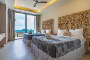 DominicalitoCasa Frenchie Luxury Oceanview Jungle Villa for 12 people的配有大窗户的酒店客房内的两张床