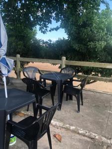 Pousada e Restaurante na Orla de Colares的围栏旁的一组黑桌椅