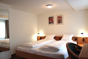 安特拉格里Hotel Freihof Swiss Lodge的一间卧室配有两张床、一张桌子和一把椅子