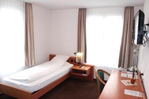 安特拉格里Hotel Freihof Swiss Lodge的酒店客房设有一张床、一张书桌和窗户。