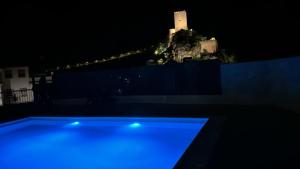 卡索拉Casa Tio Paco的享有城堡的夜间景色,设有蓝色的游泳池