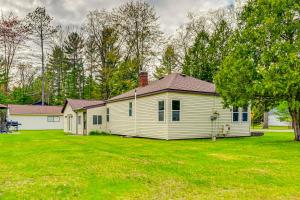 RoscommonDog-Friendly Roscommon Cabin, Walk to Higgins Lake的草地庭院中的白色房子